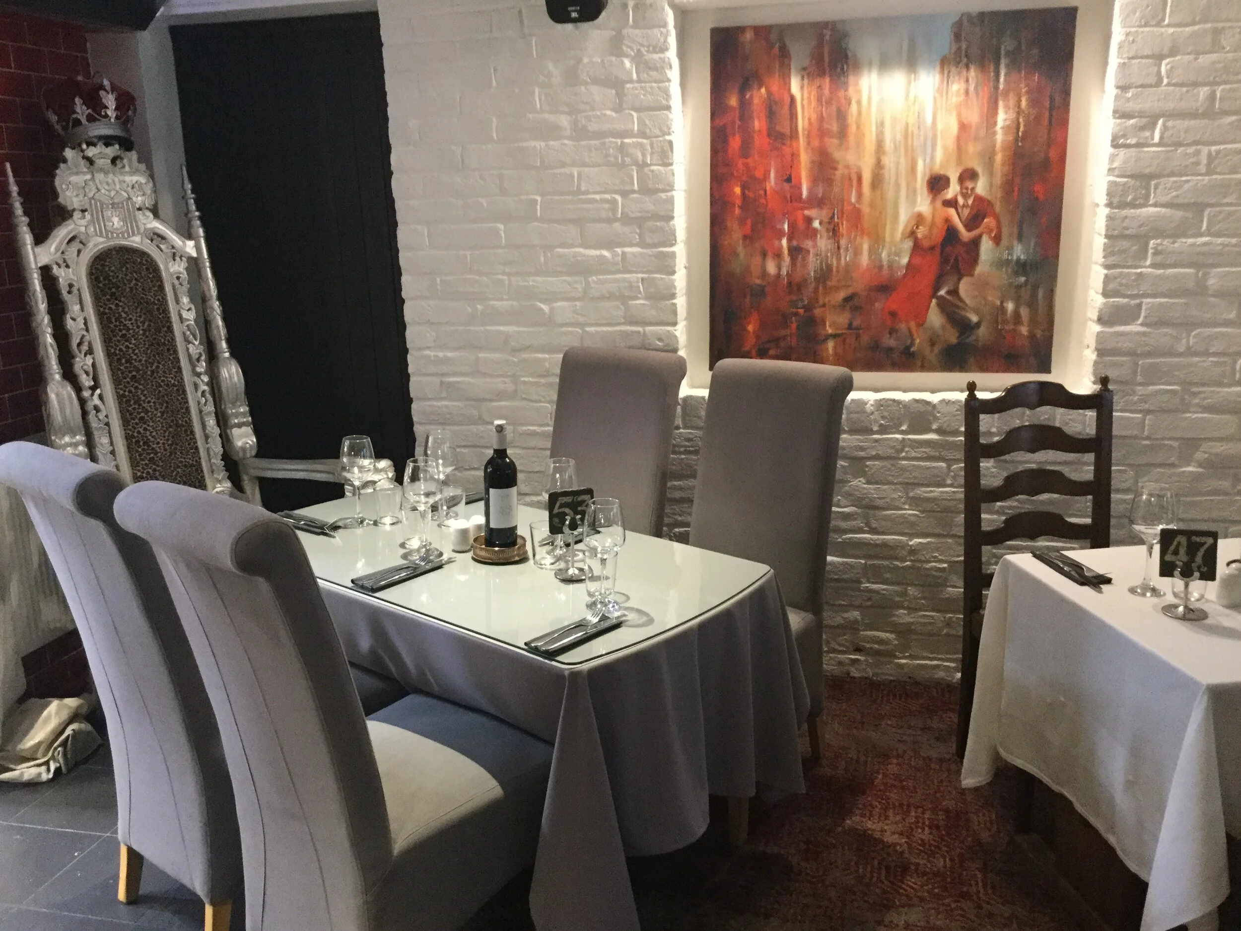 Dining room with white linen and artwork